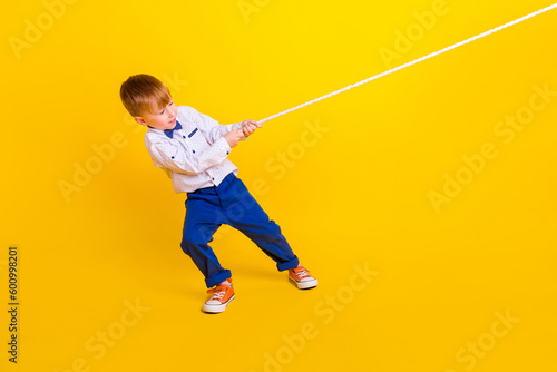 Foto Profile side full length photo of little schoolkid boy pull heavy rope tug war g