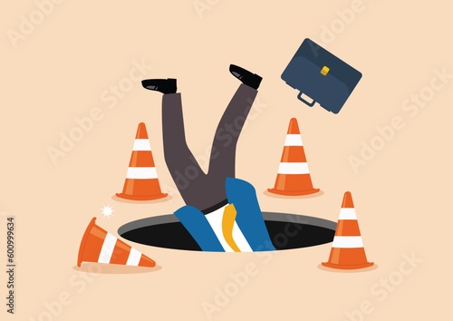 Terrified businessman fall down into the hole