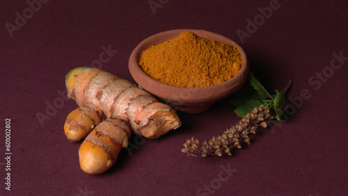 Turmeric powder in wooden bowl and fresh turmeric root on textured background. Herbs are native ,Food and drink, diet nutrition, health care concept.