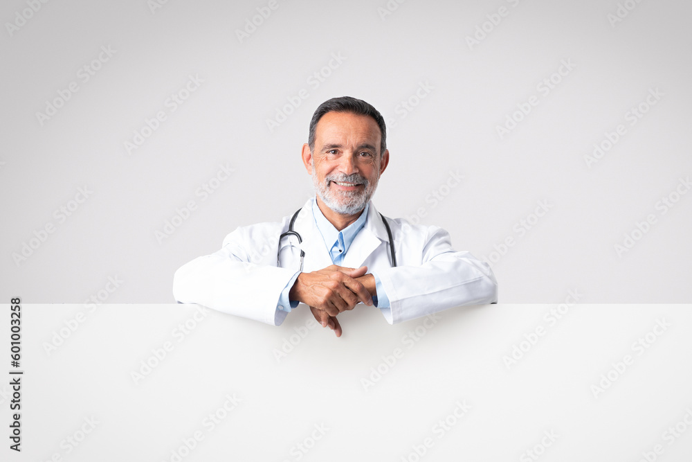 Smiling confident european senior man doctor with open mouth in white coat with stethoscope with big banner Smiling confident european senior man doctor with open mouth in white coat with stethoscope with big banner