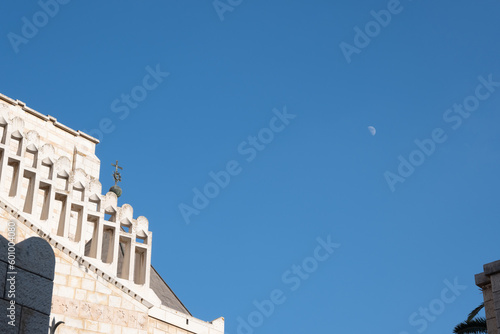Nazareth, Israel - August 16, 2021: facade of church in Nazareth with a moon in the sky photo
