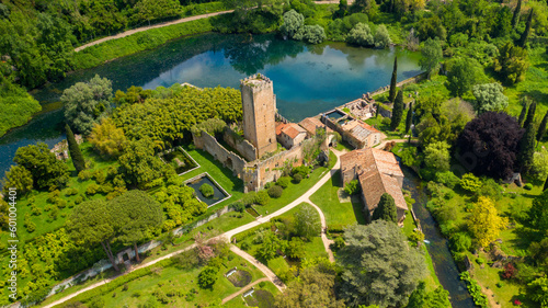 Aerial view of the ruins of the castle and tower located in the garden of Ninfa  near Latina  Italy. The park is an Italian natural monument and contains a lake and a river. It is empty.