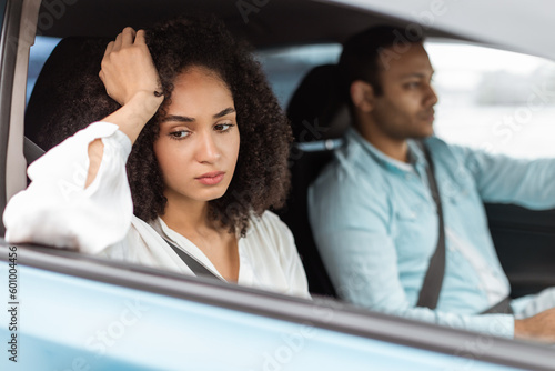 Unhappy Middle Eastern Lady Sitting In Car Salon Near Husband