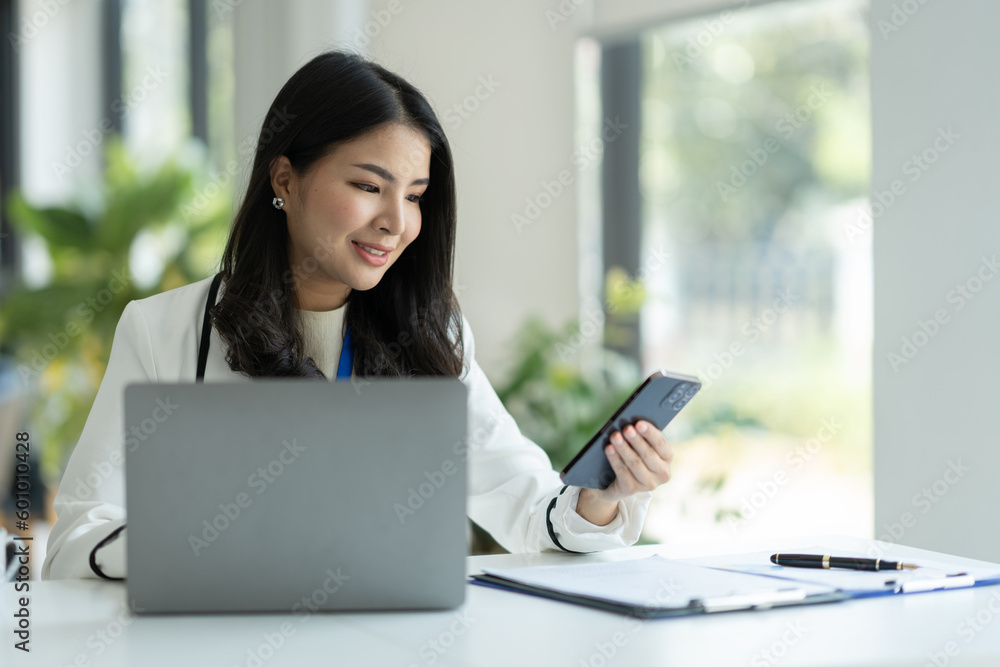 Confident businesswoman using mobile smartphone and working online through laptop E-learning about business in finance, insurance, management concepts. Confident businesswoman using mobile smartphone and working online through laptop E-learning about business in finance, insurance, management concepts.