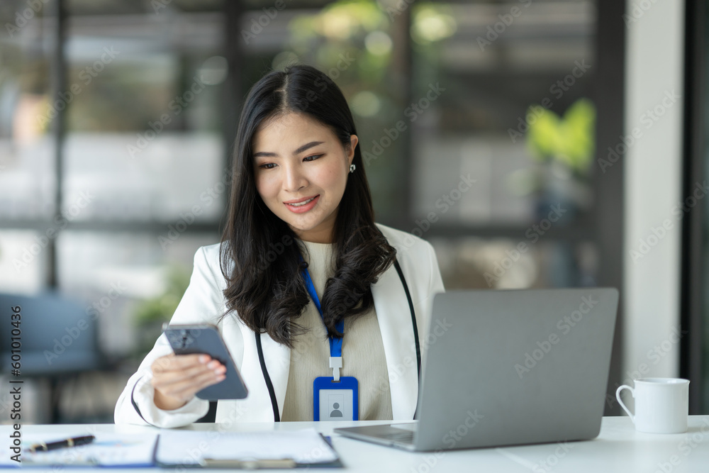 Confident businesswoman using mobile smartphone and working online through laptop E-learning about business in finance, insurance, management concepts. Confident businesswoman using mobile smartphone and working online through laptop E-learning about business in finance, insurance, management concepts.