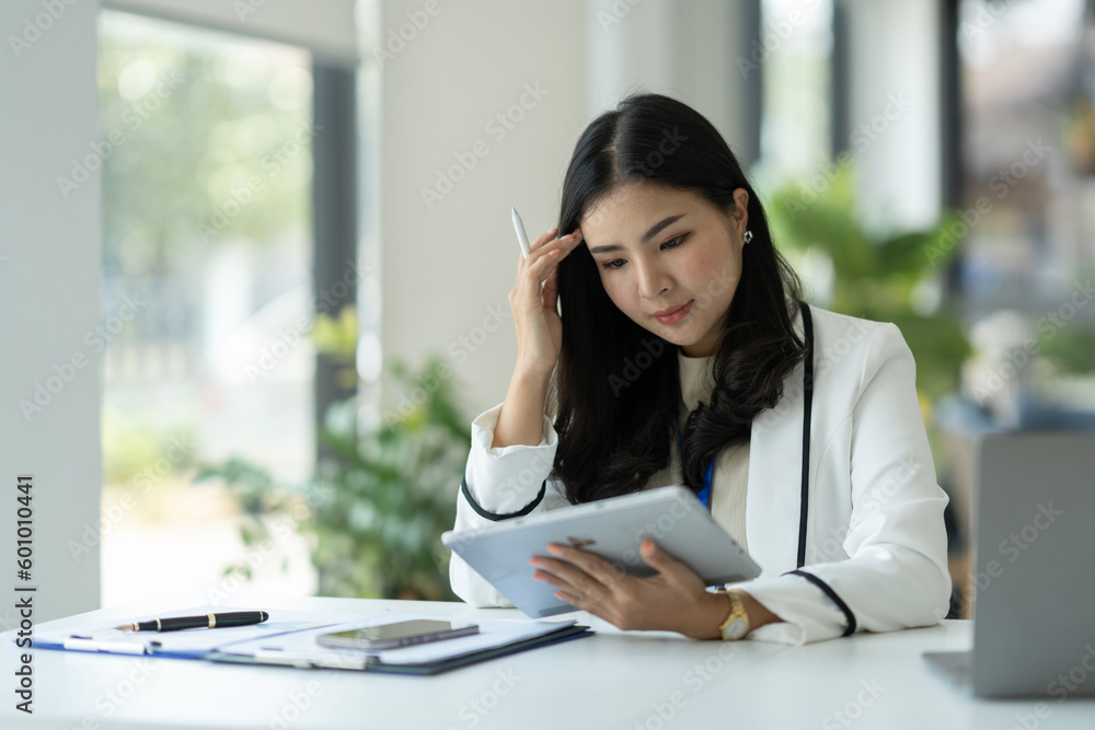 Confident businesswoman, corporate employee working online on tablet E-learning about business in finance, insurance, income, tax at the office management concept. Confident businesswoman, corporate employee working online on tablet E-learning about business in finance, insurance, income, tax at the office management concept.