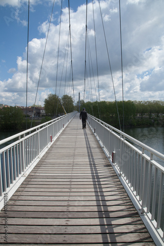 Homme solitaire franchissant une passerelle au-dessus de la Garonne à Agen (Lot-et-Garonne)