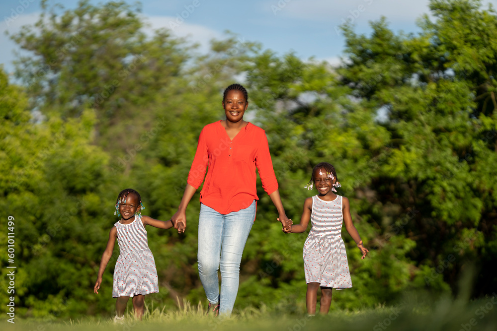 Two black-skinned sisters sunset with their mom Two black-skinned sisters sunset with their mom