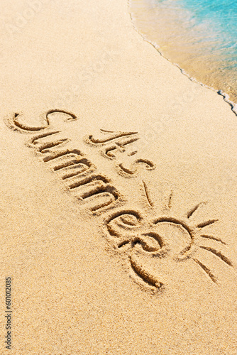 It is Summer written text on sunny beach with sea wave. Travel and holidays seasonal concept photo.