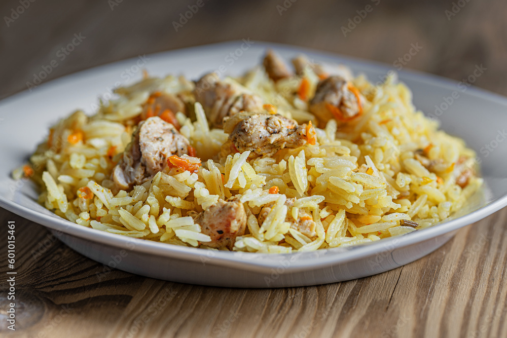 cooked at home hot delicious spicy pilaf with chicken on a white plate