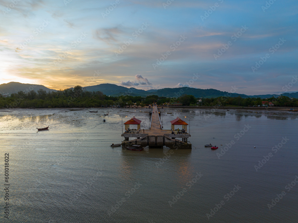 aerial photography cloud above Palai pier at beautiful sunset..Palai pier is next to Chalong pier..fishing boats parking on the beach..colorful cloud above the mountain range background..