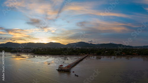 aerial photography cloud above Palai pier at beautiful sunset..Palai pier is next to Chalong pier..fishing boats parking on the beach..colorful cloud above the mountain range background..