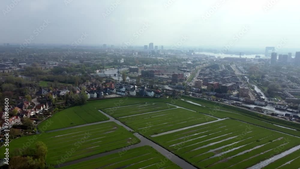Green Fields With Water Canals On The Bank Of Zijkanaal I In North Amsterdam Near City Center And IJ River In The Netherlands. wide aerial Green Fields With Water Canals On The Bank Of Zijkanaal I In North Amsterdam Near City Center And IJ River In The Netherlands. wide aerial