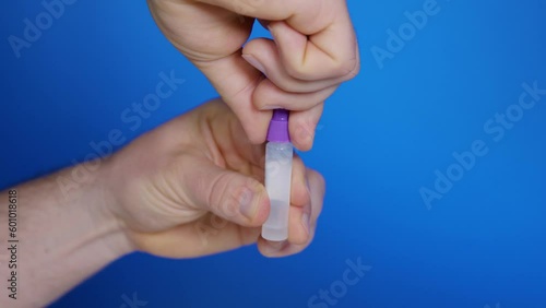 Open cap of transparent plastic vial with extraction solution for self-testing photo