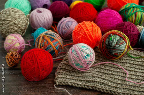 Balls of yarn for knitting close-up. Knitting is a type of needlework. The yarn lies on a knitted scarf.