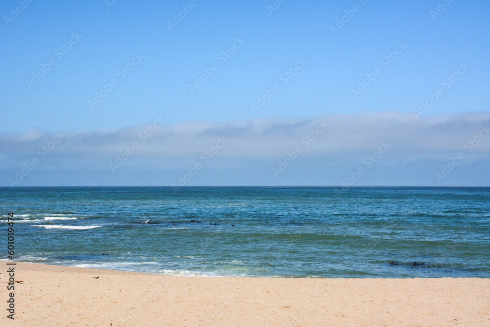Empty sandy beach with turquoise sea waves. Summer seascape.