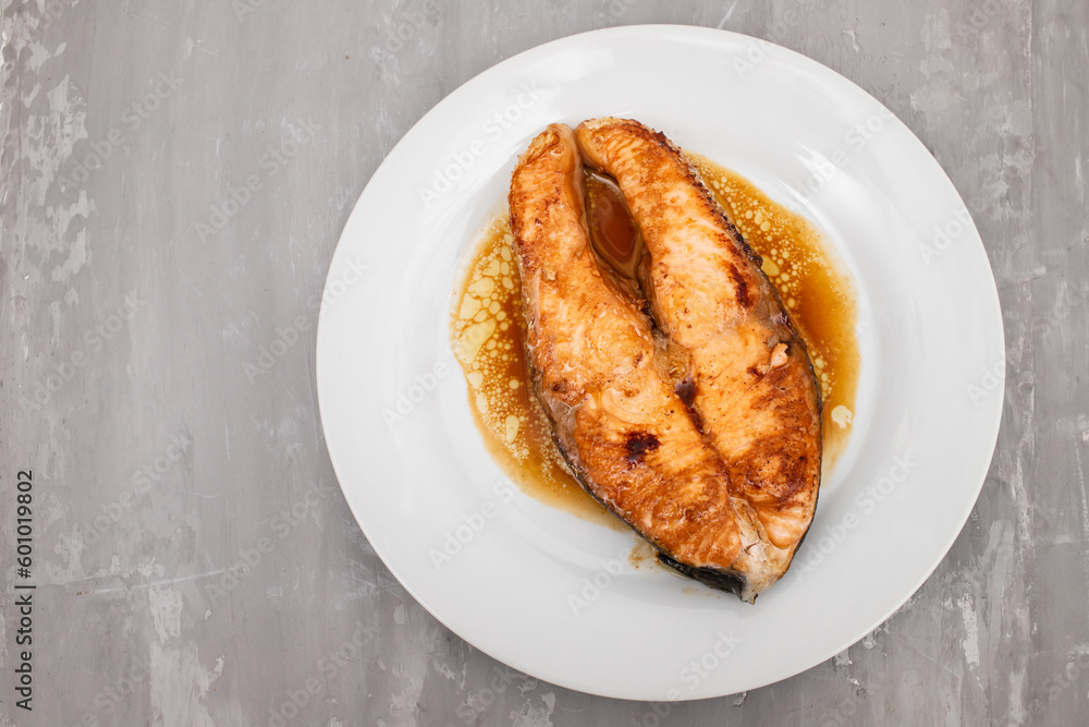 Fried salmon steak with sauce on white dish Fried salmon steak with sauce on white dish
