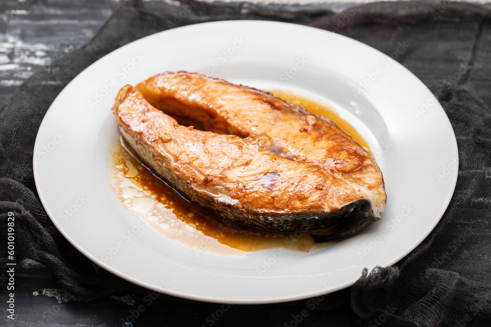 Fried salmon steak with sauce on white dish Fried salmon steak with sauce on white dish