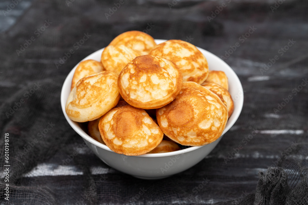 Heap of mini cereal pancakes in bowl on bright background. Heap of mini cereal pancakes in bowl on bright background.
