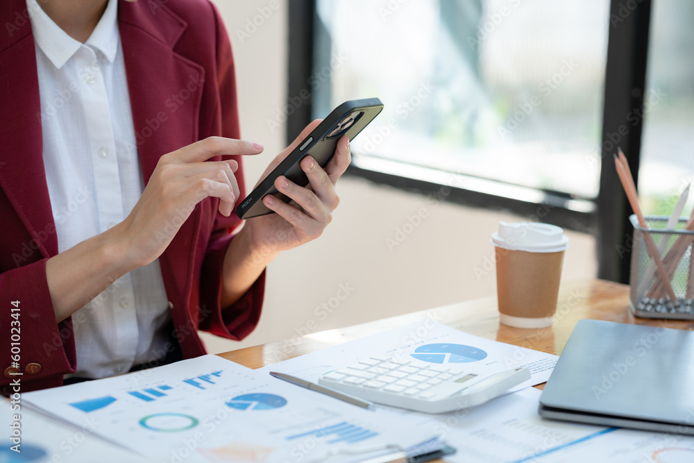 Beautiful smiling asian businesswoman sitting analyzing charts and