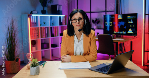 Schilderij op canvas Pretty confident modern experienced brunette in headset wearing stylish clothes