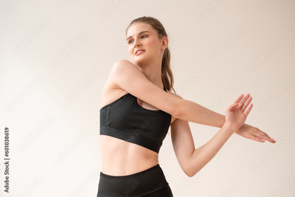 Fototapeta premium Young woman dressed in sportswear doing fitness exercises at home