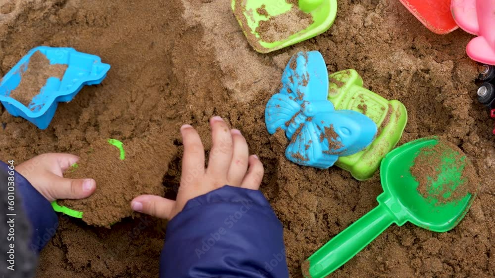 Close up hands of baby toddler playing in the sandbox Close up hands of baby toddler playing in the sandbox