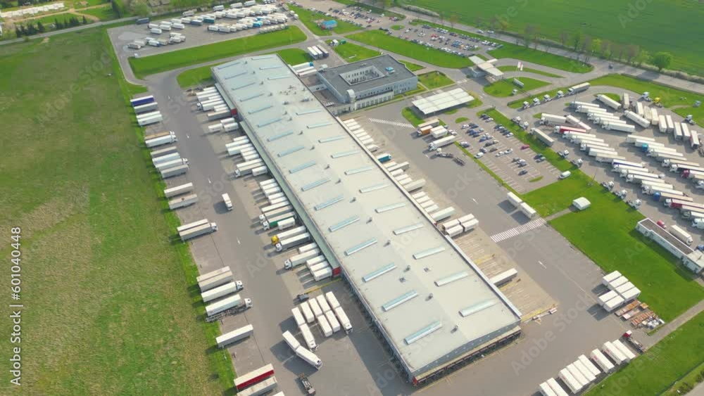 Aerial view of goods warehouse. Logistics center in industrial city zone from above. Aerial view of trucks loading at logistic center. View from drone. Aerial view of goods warehouse. Logistics center in industrial city zone from above. Aerial view of trucks loading at logistic center. View from drone.