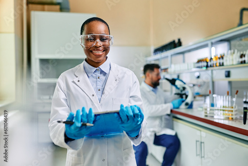 Happy black female scientist in laboratory looking at camera.