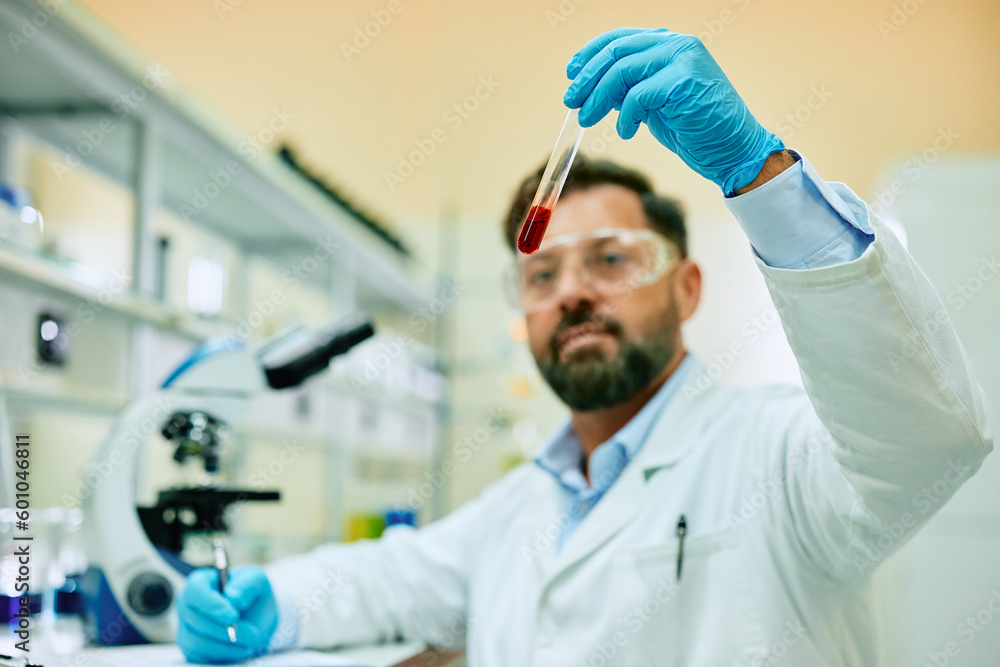 Close up of scientist examining chemical substance in test tube while working in laboratory. Close up of scientist examining chemical substance in test tube while working in laboratory.