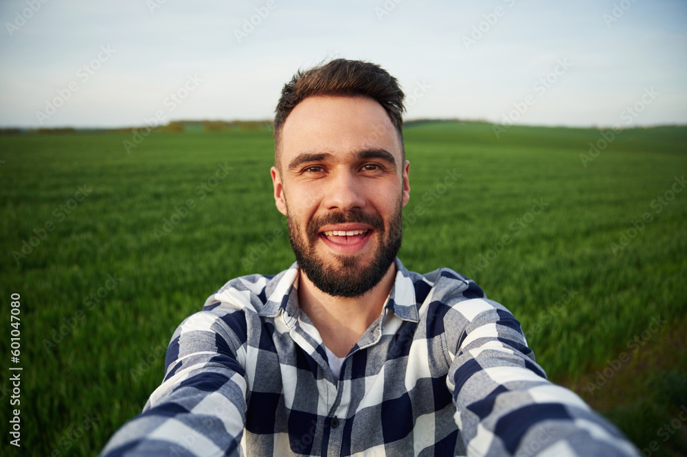 Making selfie. Handsome young man is on agricultural field Making selfie. Handsome young man is on agricultural field