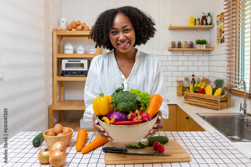 African American housewife is showing variety of organic vegetables to ...