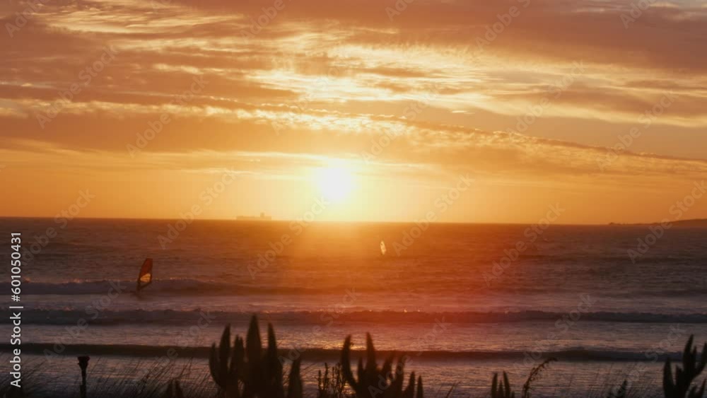 Windsurfers on the sea with beautiful sunset beachshore Windsurfers on the sea with beautiful sunset beachshore