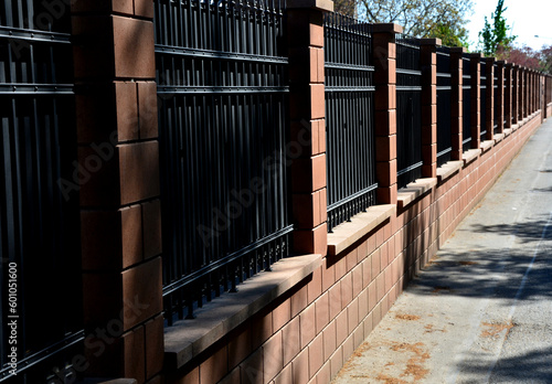 fencing of building from forged bars with curved spikes. military guarded bases and an embassy with increased protection against overcoming inward encirclement. black bars on fence with dangerous