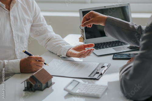 Photography Male businessman or real estate agent holding house key for his client after sig