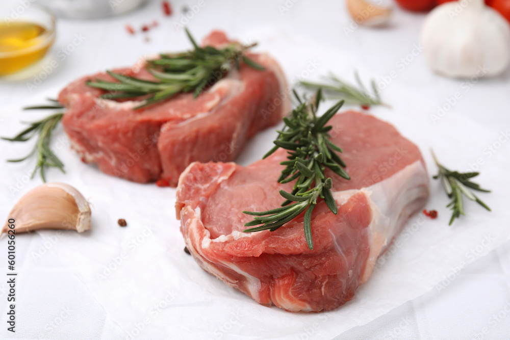 Fresh raw meat with rosemary on white table, closeup