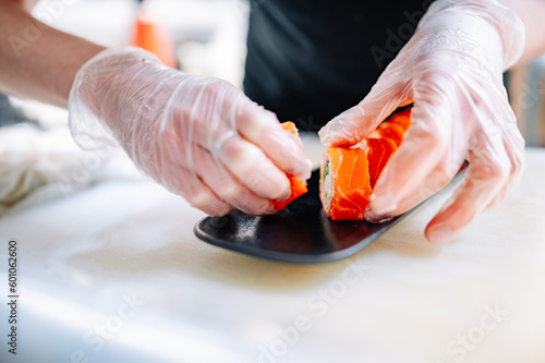 professional chef s hands making sushi roll in a restaurant kitchen