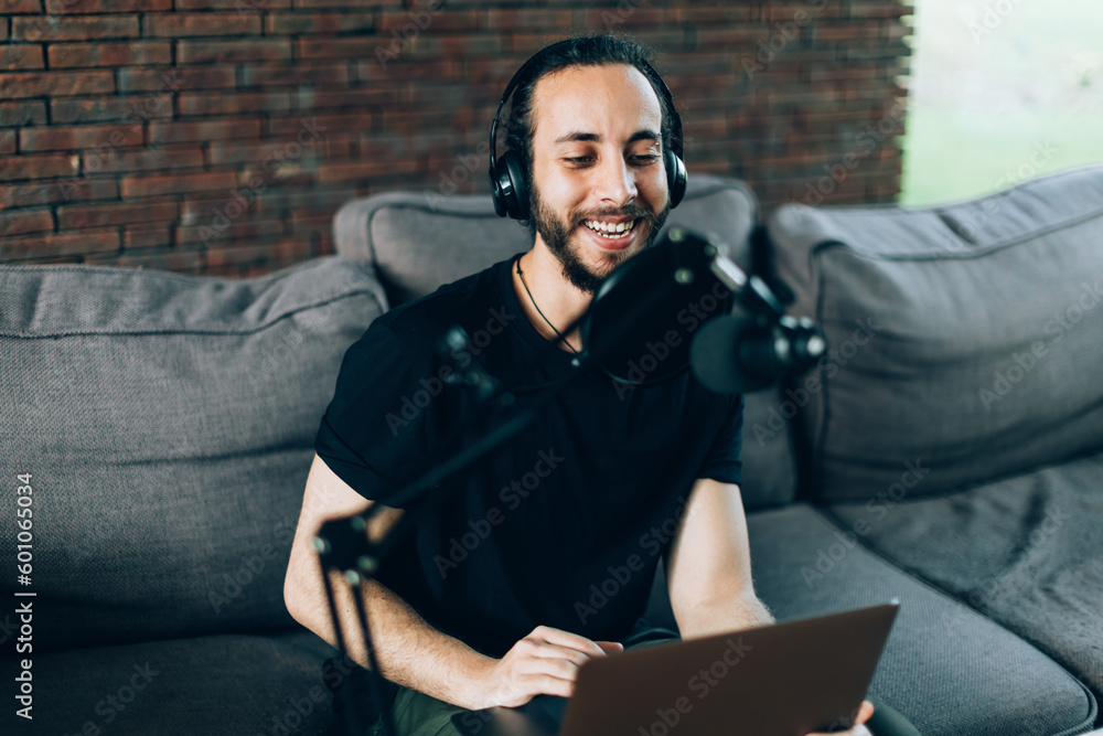 young man recording podcast and broadcasting from his home office