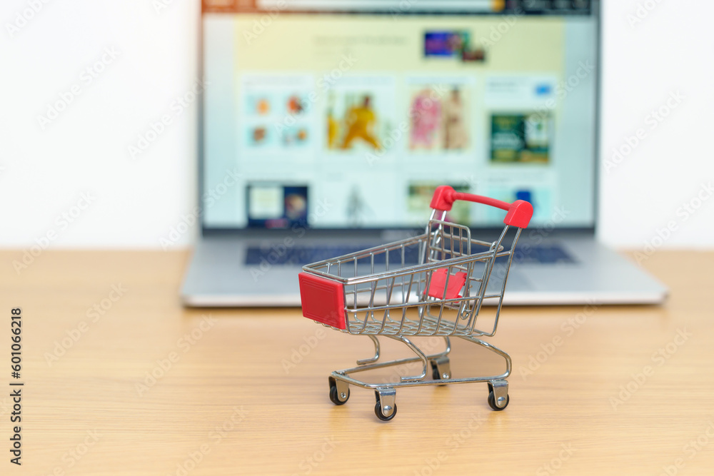 Shopping cart and laptop computer with marketplace website. Online Shopping, technology, ecommerce, SEO, Search Engine Optimization, Advertising, keyword and online payment concept Shopping cart and laptop computer with marketplace website. Online Shopping, technology, ecommerce, SEO, Search Engine Optimization, Advertising, keyword and online payment concept