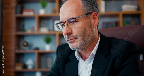 Φωτογραφία Attractive concentrated skilled hardworking bearded businessman in glasses sitti