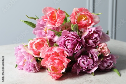 Beautiful bouquet of colorful tulip flowers on light table  closeup