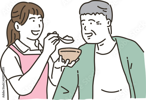 食事介助をする女性介護士と高齢者男性