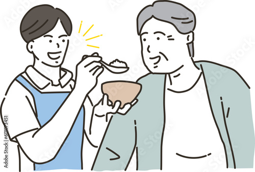 食事介助をする男性介護士と高齢者男性