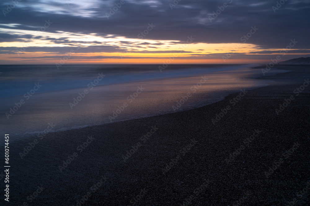 Abendstimmung am Strand an der Nordsee nach Sonnenuntergang bei einem farbenfrohen Himmel Abendstimmung am Strand an der Nordsee nach Sonnenuntergang bei einem farbenfrohen Himmel