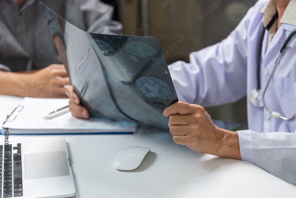 Asian woman doctor watching patient x-ray film, MRI and CT scan. Health care concept. Asian woman doctor watching patient x-ray film, MRI and CT scan. Health care concept.