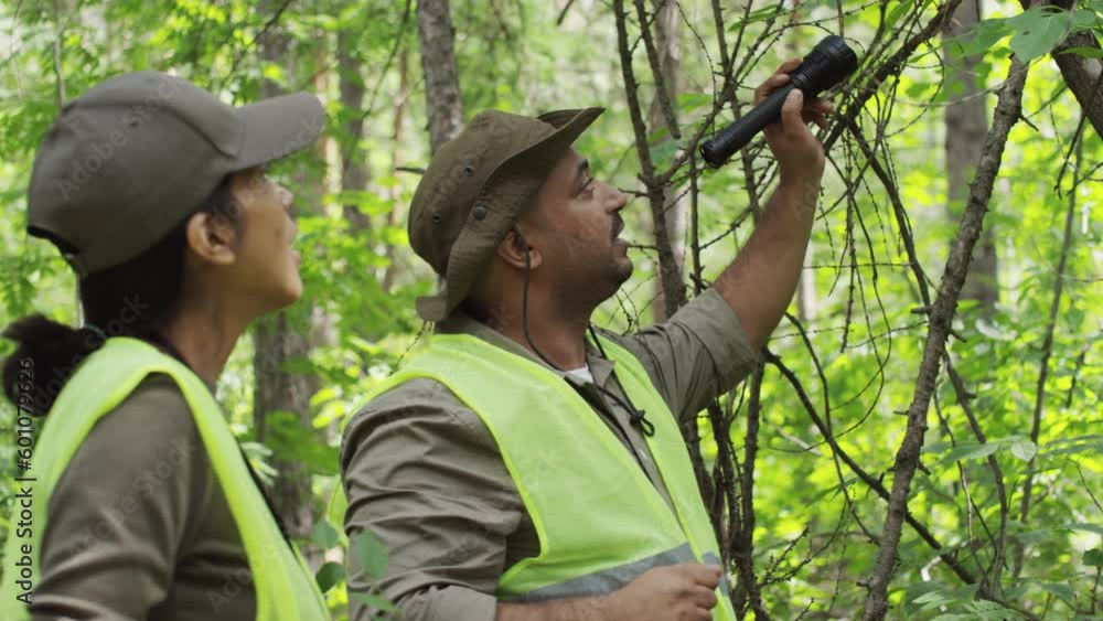 Medium shot of Indian male forest ranger in khaki uniform and yellow