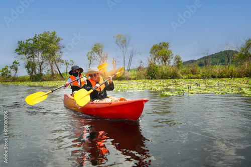 Two Asian female kayakers rowing with free space ,Asian women rowing to study nature
