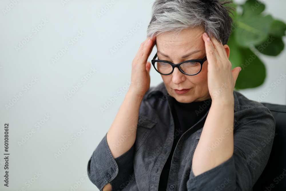 Portrait of a senior woman holding her head with her hands, migraine. Portrait of a senior woman holding her head with her hands, migraine.