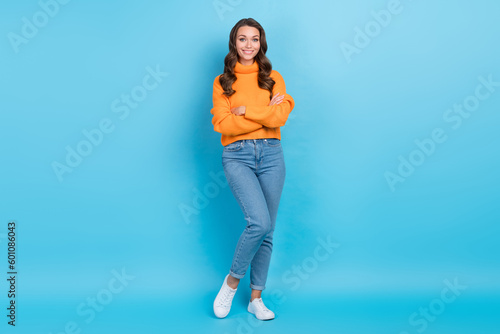 Full length photo of positive confident lady dressed orange pullover arms crossed isolated blue color background