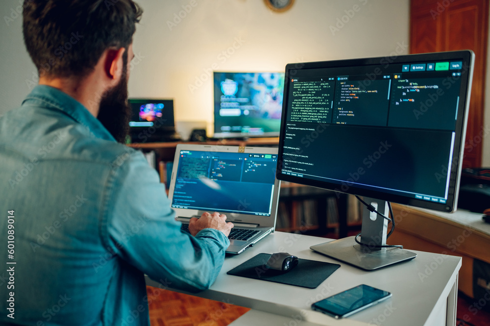 Rear view of an IT expert working on AI generators and AI bots at his home office by writing code at home. Rear view of an IT expert working on AI generators and AI bots at his home office by writing code at home.